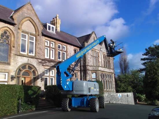 Holdsworth Roofing working at height from a cherry picker on a stone building